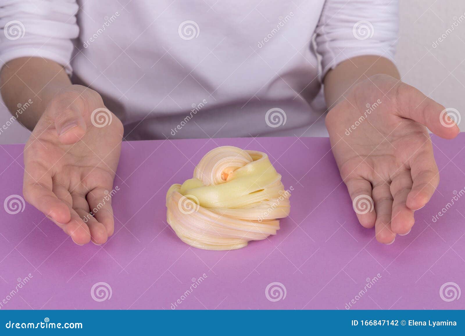 slime on a purple table. two hands around yellow slime.ÃÂ¡onceptual hobbies